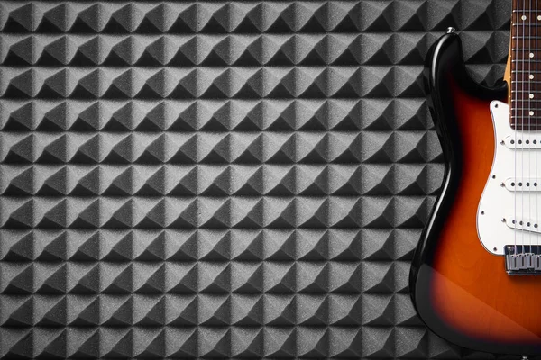 Top view of electric guitar on acoustic foam panel background, closeup — Stock Photo, Image