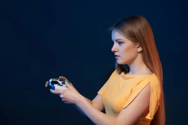 Perfil de una chica jugando videojuegos con joystick sobre fondo azul —  Fotos de Stock