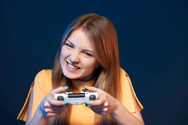 ゲーマーの女の子 感情的な女の子遊びビデオゲームとともにジョイスティック クローズアップポルノの青の背景 — ストック写真