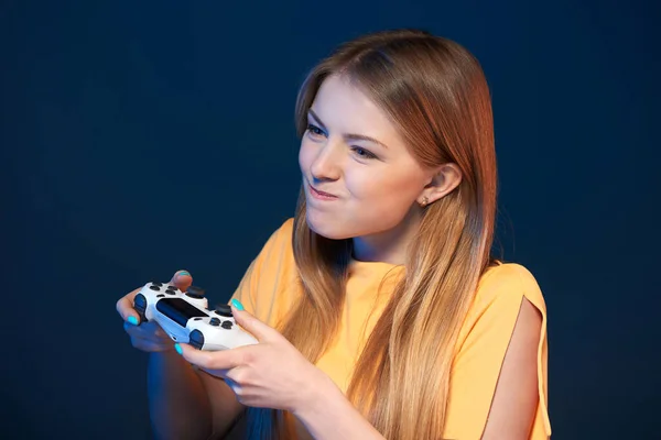 ゲーマーの女の子 感情的な女の子再生ビデオゲームともにジョイスティック見るアウトフレーム作り面白い顔 閉じられたポルノの青の背景 — ストック写真
