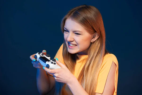 ゲーマーの女の子 感情的な女の子遊びビデオゲームともにジョイスティック見るアウトフレーム 接写ポートレート上の青の背景 — ストック写真