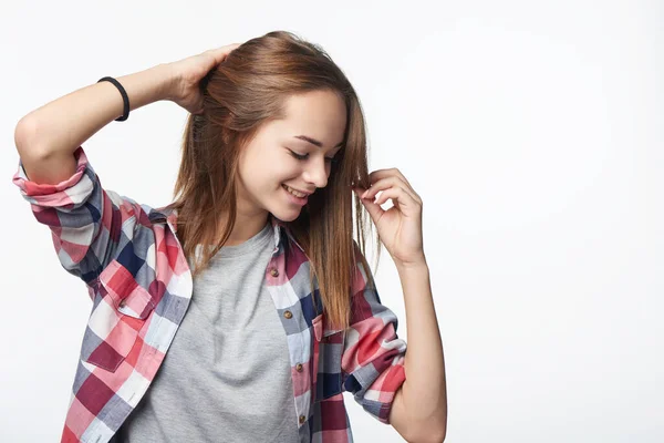 Uśmiechnięty Zrelaksowany Nastolatek Dziewczyna Dotykając Jej Włosy Patrząc Dół Studio — Zdjęcie stockowe