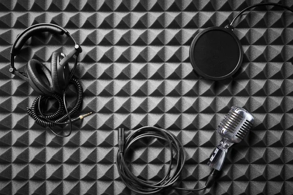 アコースティックフォームパネルの背景に横たわるレトロマイク プロのヘッドフォンやポップアップフィルター フラットレイ — ストック写真