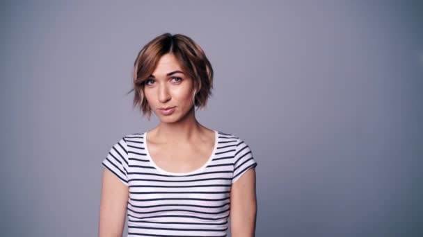 Gelukkig vrouw in stripped t-shirt kijken naar camera glimlachen — Stockvideo