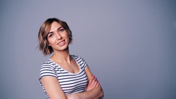 Gelukkig vrouw in stripped t-shirt kijken naar camera glimlachen — Stockvideo