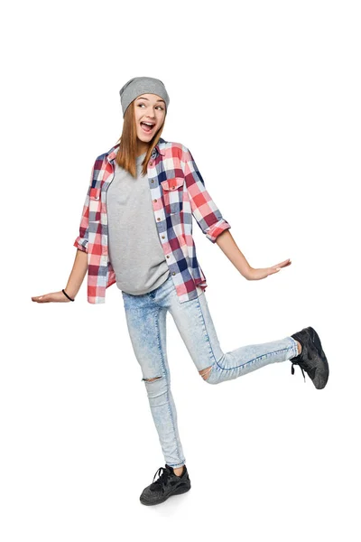 Menina adolescente emocional feliz vestindo camisa xadrez casual e chapéu gorro, pulando olhando para o lado surpreso — Fotografia de Stock