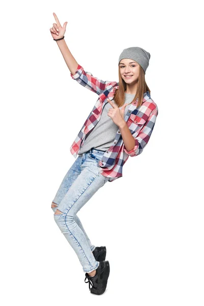 Tiener meisje staan in volle lengte op tiptoe wijzend naar kant op blanco kopieerruimte — Stockfoto