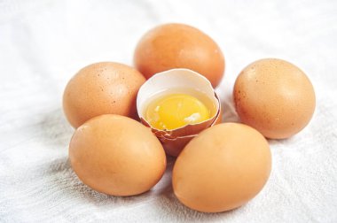 beyaz zemin üzerinde kahverengi yumurta. bir yumurta kırılmış.