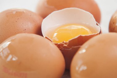 beyaz zemin üzerinde kahverengi yumurta. bir yumurta kırılmış.