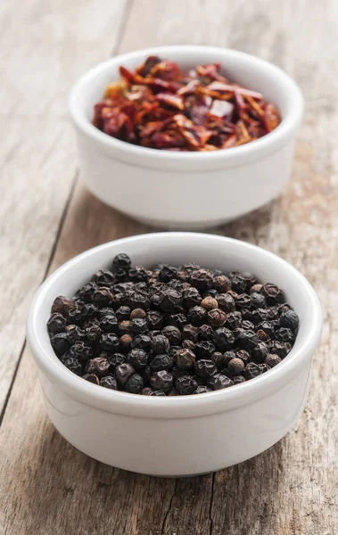 Black pepper on wood background — Stock Photo, Image