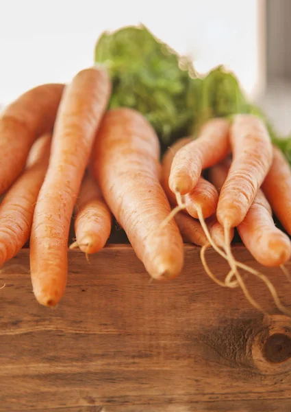 Ramo de zanahorias frescas en madera — Foto de Stock