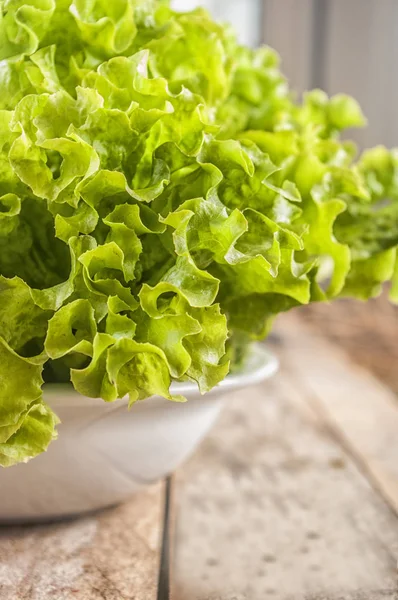 Green lettuce leaves. Lettuce leaves on wooden background. Fresh lettuce on kitchen table. Healthy organic food.