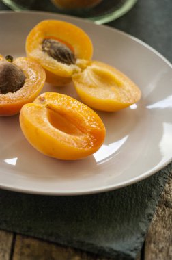 Tüm turuncu kayısı yukarıdan, metin için yer kırmızı allık ile. Taş ve yaprakları açık kayısı. Rustik beyaz tahtaya.