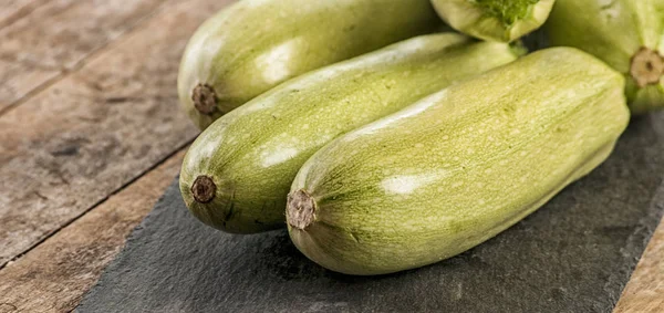 Fresh zucchini on wooden background — Stock Photo, Image