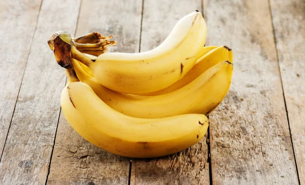 Ahşap arka plan üzerinde muz grup