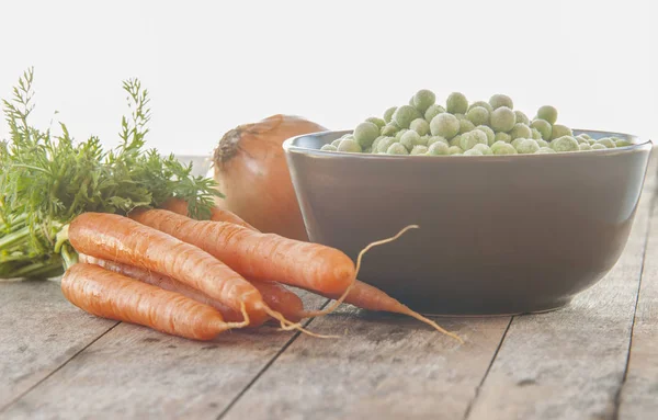 Eine Schüssel gefrorener grüner Erbsen mit Karotten — Stockfoto