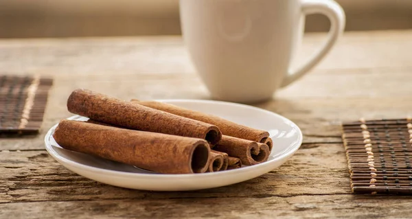 Canela no fundo de madeira e café — Fotografia de Stock