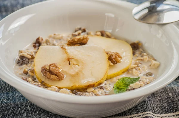 Harina de avena con pera y nueces en el bowl — Foto de Stock