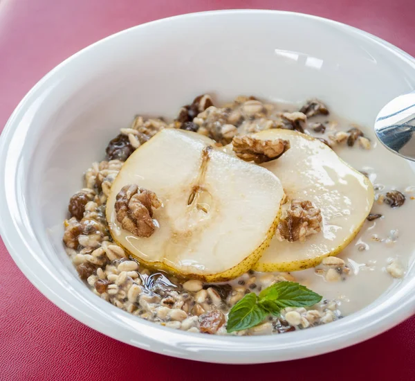 Harina de avena con pera y nueces en el bowl — Foto de Stock