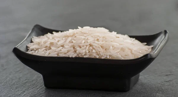 Arroz basmati sobre fundo preto — Fotografia de Stock