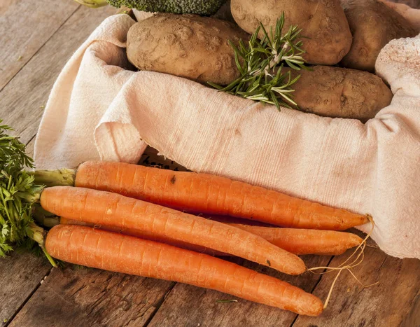 Patatas y zanahorias sobre fondo de madera — Foto de Stock