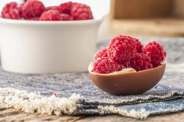 Raspberries in chocolate egg shell — Stock Photo, Image