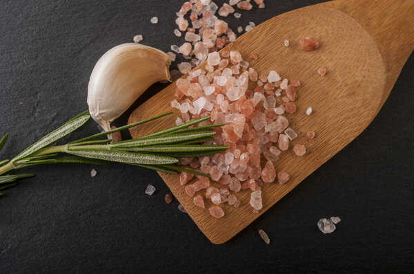 garlic and rosemary on wooden stirring spoon