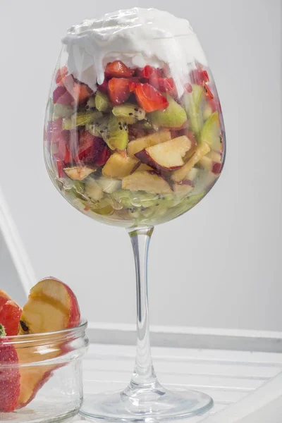 Zoete dessert met fruit en slagroom in een wijnglas — Stockfoto