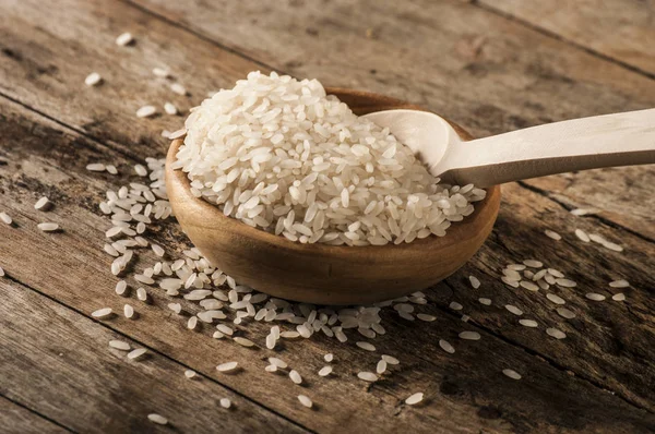 Raw rice in bowl with spoon