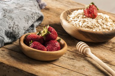 Ahşap masa üzerinde çilek kase yulaf gevreği. Seçici odak.