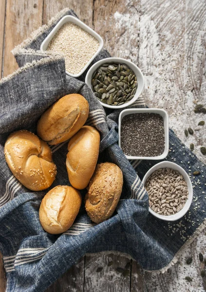 Свежие рулоны и свежеиспеченный хлеб с различными полезными семенами — стоковое фото