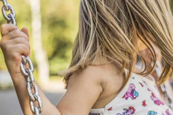 küçük kız açık salıncakta eğleniyor