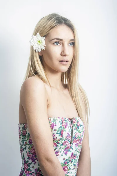 Porträt eines schönen und sanften blonden Mädchens im Studio auf blauem Hintergrund im Kleid, das Konzept von Schönheit und Gesundheit — Stockfoto