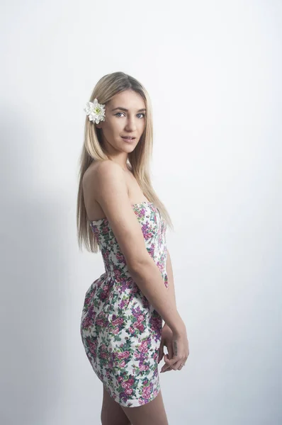 Porträtt av en vacker och mild blond flicka i studion på en blå bakgrund i klänningen, begreppet skönhet och hälsa — Stockfoto