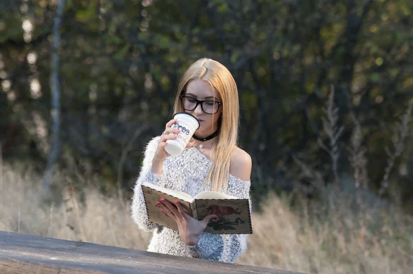 Donna autunnale che beve caffè. Autunno concetto di giovane donna godendo bevanda calda da tazza di caffè usa e getta nel paesaggio autunnale . — Foto Stock