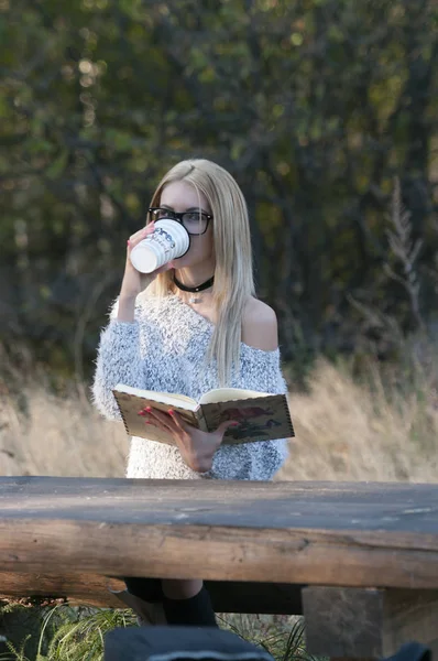 Donna autunnale che beve caffè. Autunno concetto di giovane donna godendo bevanda calda da tazza di caffè usa e getta nel paesaggio autunnale . — Foto Stock