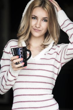 Kız sıcak kahve içiyor.