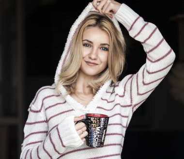 Kız sıcak kahve içiyor.