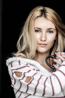 Kız sıcak kahve içiyor.