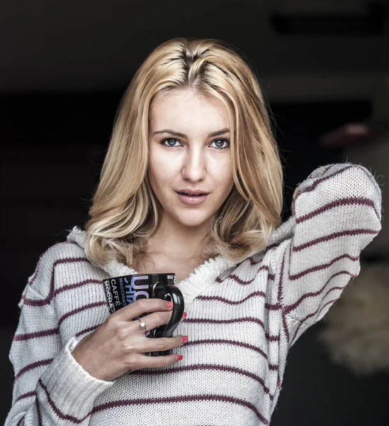 Kız sıcak kahve içiyor.