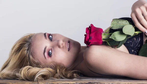 Aantrekkelijke vrouw bedrijf rode roos — Stockfoto