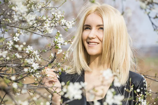 Güzel mutlu genç kadının kokusu bir çiçekli bahar bahçe