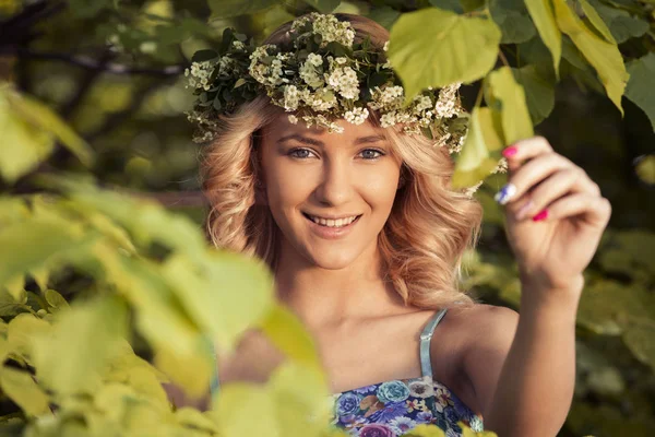 Portrét krásné sexy usměvavá dívka s věncem na hlavě v parku na jaře — Stock fotografie