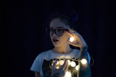 Gülümseyen ve çelenk ışıkların konuşmak güzel genç kadın 