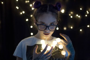 Gülümseyen ve çelenk ışıkların konuşmak güzel genç kadın 