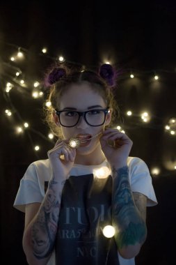 Gülümseyen ve çelenk ışıkların konuşmak güzel genç kadın 