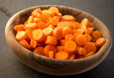 Ahşap kase çevrelerde doğranmış havuç