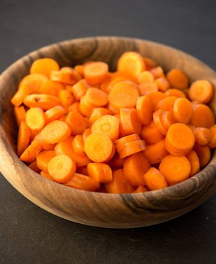 Ahşap kase çevrelerde doğranmış havuç