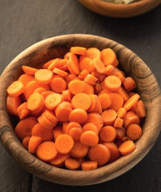 Tablo, doğranmış havuç ahşap kase daireler ile yakın çekim 