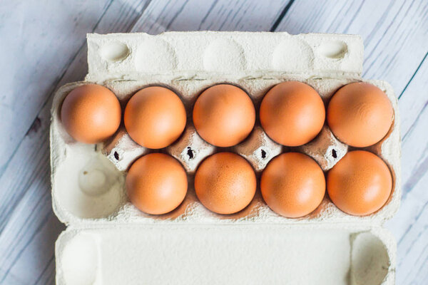chicken eggs in cardboard container on wooden table, close-up,  easter concept